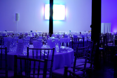 a photo of several set tables lit in blue