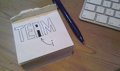 Drawing of the word TEAM where the inside of the letter A makes a lower case letter i
