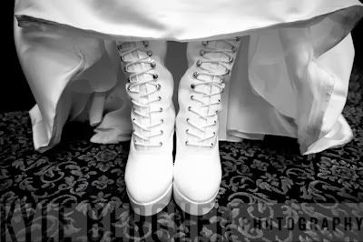 Black and white photo of Bride's white patent leather lace up boots