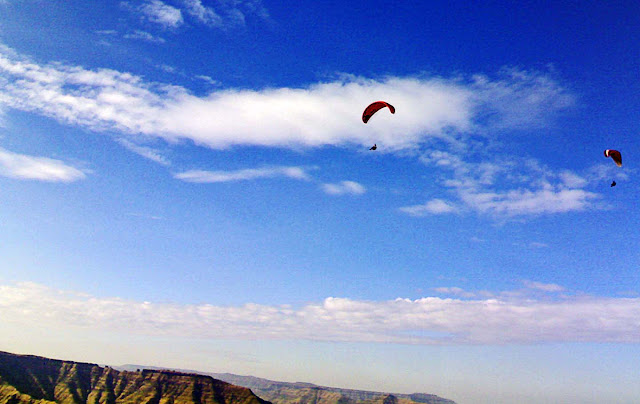 two flyers paragliding over mountains