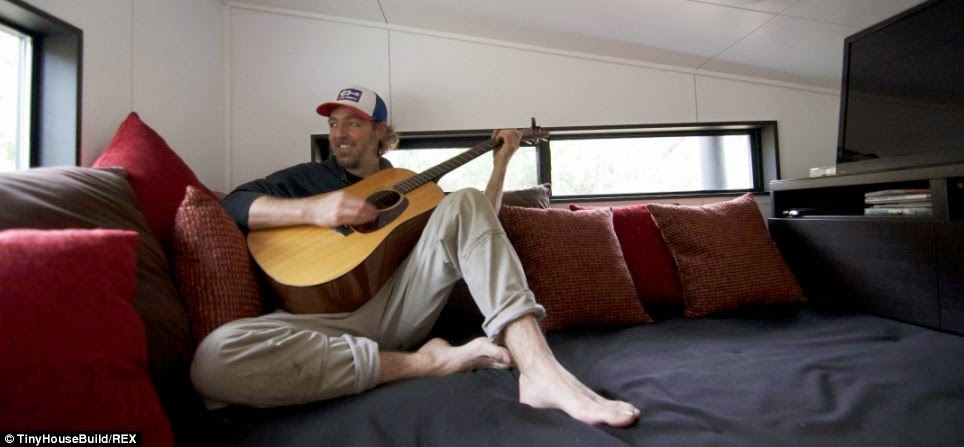 Mr. Morrison plays his guitar and relaxes in his new lounge, which his wife says has brought them closer as a family - This Couple Got Out Of The Rat Race. And Built This Tiny Home For $33K. Mr. Morrison plays his guitar and relaxes in his new lounge, which his wife says has brought them closer as a family - This Couple Got Out Of The Rat Race. And Built This Tiny Home For $33K.