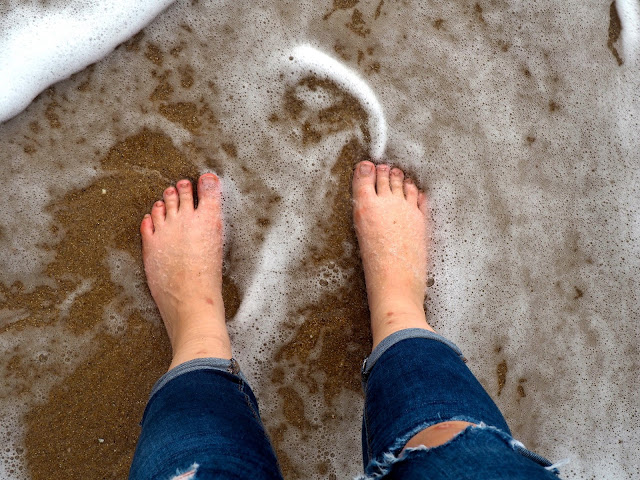 Rolled up jeans and bare feet paddling in the sea at Hung Shing Yeh beach, Lamma Island, Hong Kong