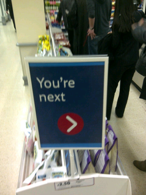 Tesco Youre Next sign, you're next, chilling sign, store supermarket line queue, directional signage