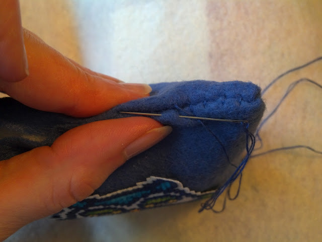 Push the needle through the fabric, parallel to the seam, on the outside of the piece