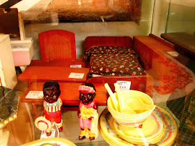 Selection of vintage dolls house bedroom furniture in an antique shop