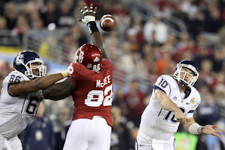 Zach Frazer #10 of the Connecticut Huskies throws the ball around the arm of Stacy McGee #92 of the Oklahoma Sooners in the third quarter during the Tostitos Fiesta Bowl at the Universtity of Phoenix Stadium on January 1, 2011 in Glendale, Arizona. (December 31, 2010 - Source: Christian Petersen/Getty Images North America) 