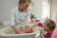 postnatal nurse bathing baby