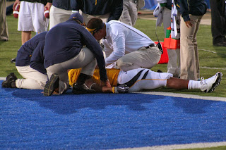 A UC-Berkeley football player receives attention from coaches and trainers after suffering a concussion.