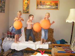 shirtless boys with giant orange balloons orange punchbag balloons