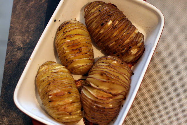 4 baked hasselback potatoes in a rectangular servicing dish.