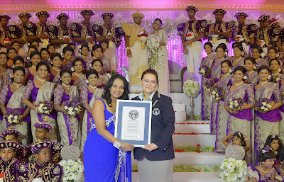 Sri Lankan wedding couple Nisansala and Nalin pose for photographers alongside their wedding party during their Guinness World Record-breaking wedding in Negombo, some 30kms north of Colombo, on November 8, 2013. Including 126 bridesmaids, 25 best men, 20 page boys and 23 flower girls the wedding breaks the previous record, held by a wedding in Bangkok that included 96 bridesmaids.