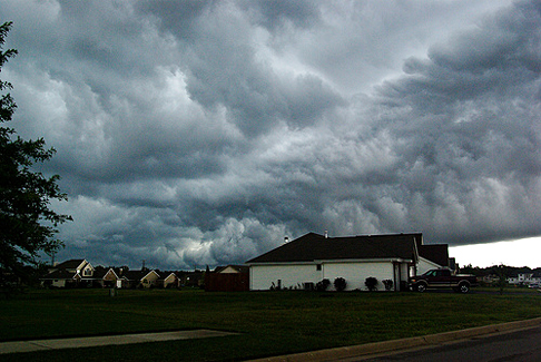 Violent storm above residences. Dark stormy skies lurk above a neighborhood