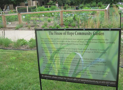 Sign next to the garden telling how the produce will be given away at the Neighborhood House food shelf