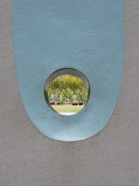 Viewing the ceramic apples through the hole in this concrete sculpture