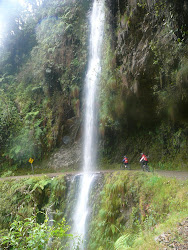 Riders approaching waterfall cascade, Road of Death (note slope and cliff edge)