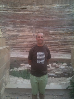 a man standing in front of a stone wall