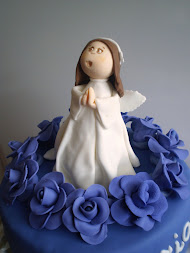 tarta de comunión con angelito y rosas moradas o azulonas