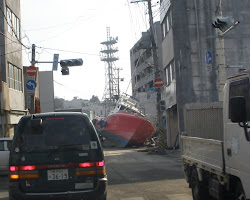 Tsunami waves bring a boat into town.