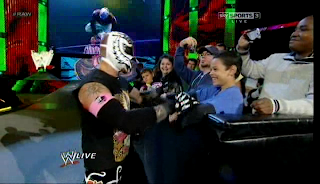 Rey Mysterio interacts with a fan before his match