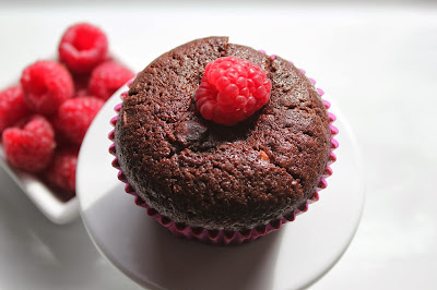 Chocolate-raspberry cheesecake muffin with bowl of raspberries