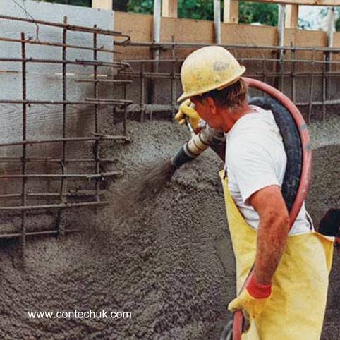Operario apunta con el extremo de una gruesa manguera a la estructura del encofrado y las varillas de acero armadura para el material Concreto esparcido con equipo de alta presión