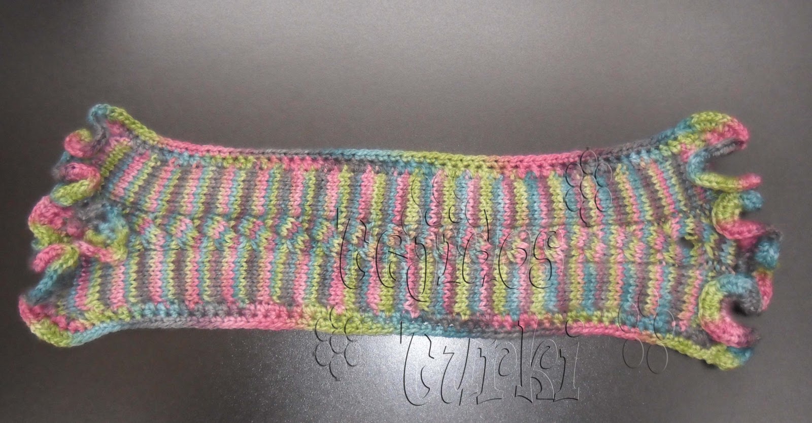 Esta bufanda collar, como las llamo, mide 46 cms. de largo x 14 cm ancho. Lleva bordes tejidos a crochet, en donde los extremos se han hecho bobitos con el