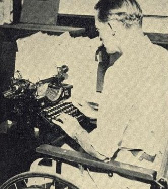 Operario en silla de ruedas trabajando  con una antigua maquina de escribir con teclas blandas