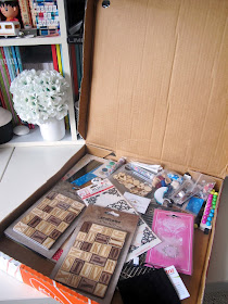 Opened pizza box, showing a range of paper craft supplies.