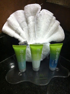 a group of small bottles of shampoo and a white towel