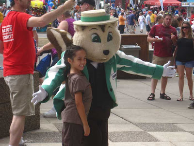 Mascot of a brown striped gopher with a green and white striped jacket and a hat