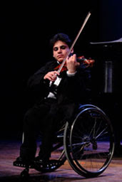 Boy who uses a wheelchair playing the violin
