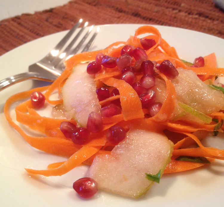 Image of a single serving of Carrot and Pear ribbon salad with pomegranate seeds on a plate