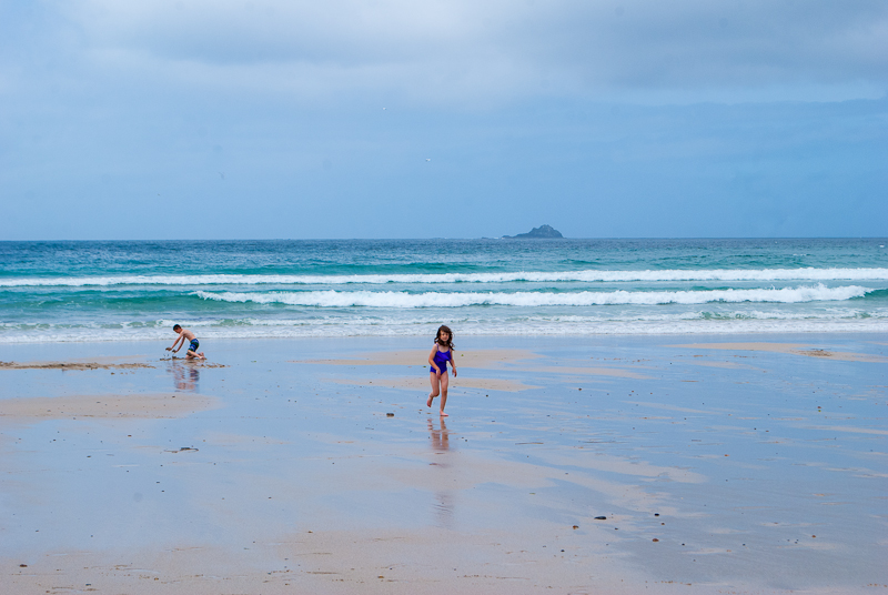 Children playing along the beach in cornwall Children playing on the beach in sennen cove west cornwall, england, UK