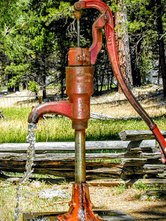 red hand pump with water flowing
