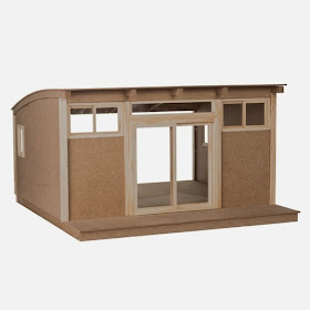 Photo of a modern dolls' house miniature shed kit with curved roof and sliding doors at the front.