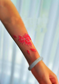 Pink petal tattoo design on the arm