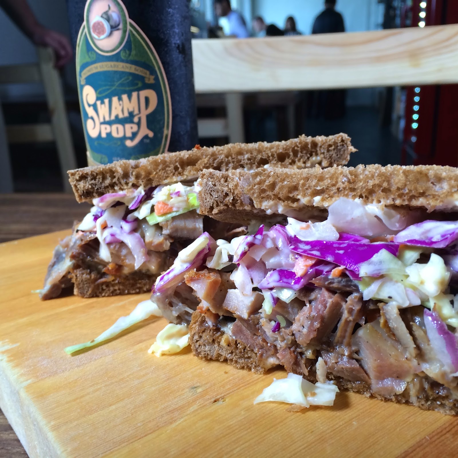 The Chop Block Melt on Rye: Pork Cheek Pastrami, Corned Beef & Smoked Beef Tongue, Slaw, Swiss and Celery Salt Mayo. Pictured with a Swamp Pop Noble Cane Cola.