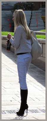 Slim blonde girl in white jeans on the street 