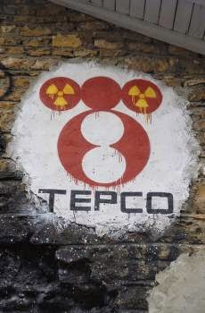 Un murales con il logo TEPCO insieme ai simboli della radiazione