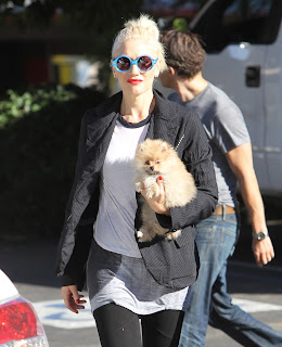 Gwen Stefani wearing some funky bright blue glasses 