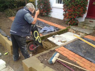 Mortar bed being poured prior to laying the path