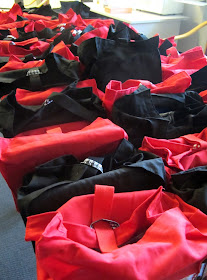 Eighty hand-made fabric goodie bags, arranged on a table.