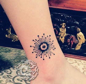 abstract dandelion tattoo on the ankle