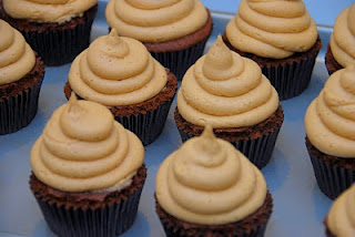 chocolate cupcakes in dark wrapper with frosting piped in a swirl on top