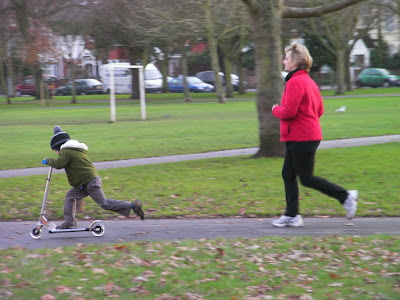 boy on christmas present scooter and jogging mother