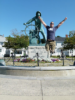 a man jumping in front of a statue