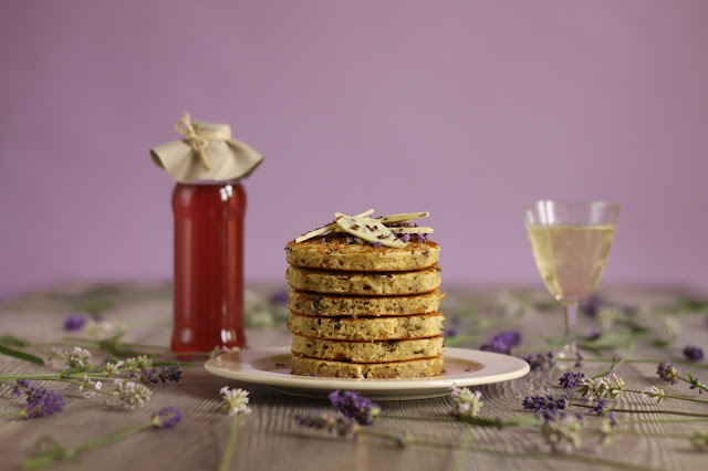 A sweet summery pancake stack with melted white chocolate bits and dried lavender in the batter with some homemade organic lavender syrup and white chocolate bark. Yummy recipe brought to you by the German food blog Pancake Stories. #pancakestories