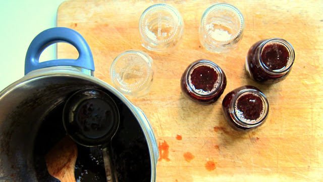 pressure cooker strawberry jam being ladeled into jars