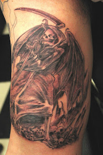 arm tattoo: Grim Reaper / Angel of Death portrayed as a hideous skeleton with giant bat-wings