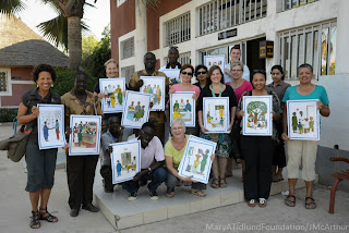The Senegal medical team and translators holding Tostan health and human rights posters.